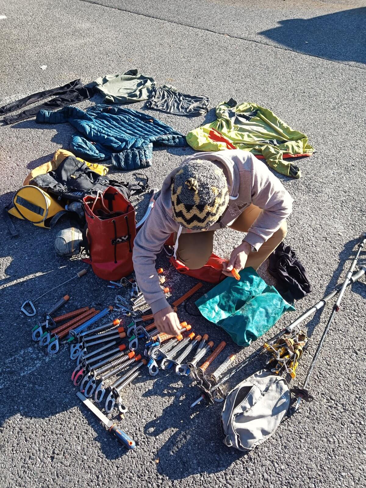 Glacier and caving gear laid out on the ground: personal and shared equipment mixed together