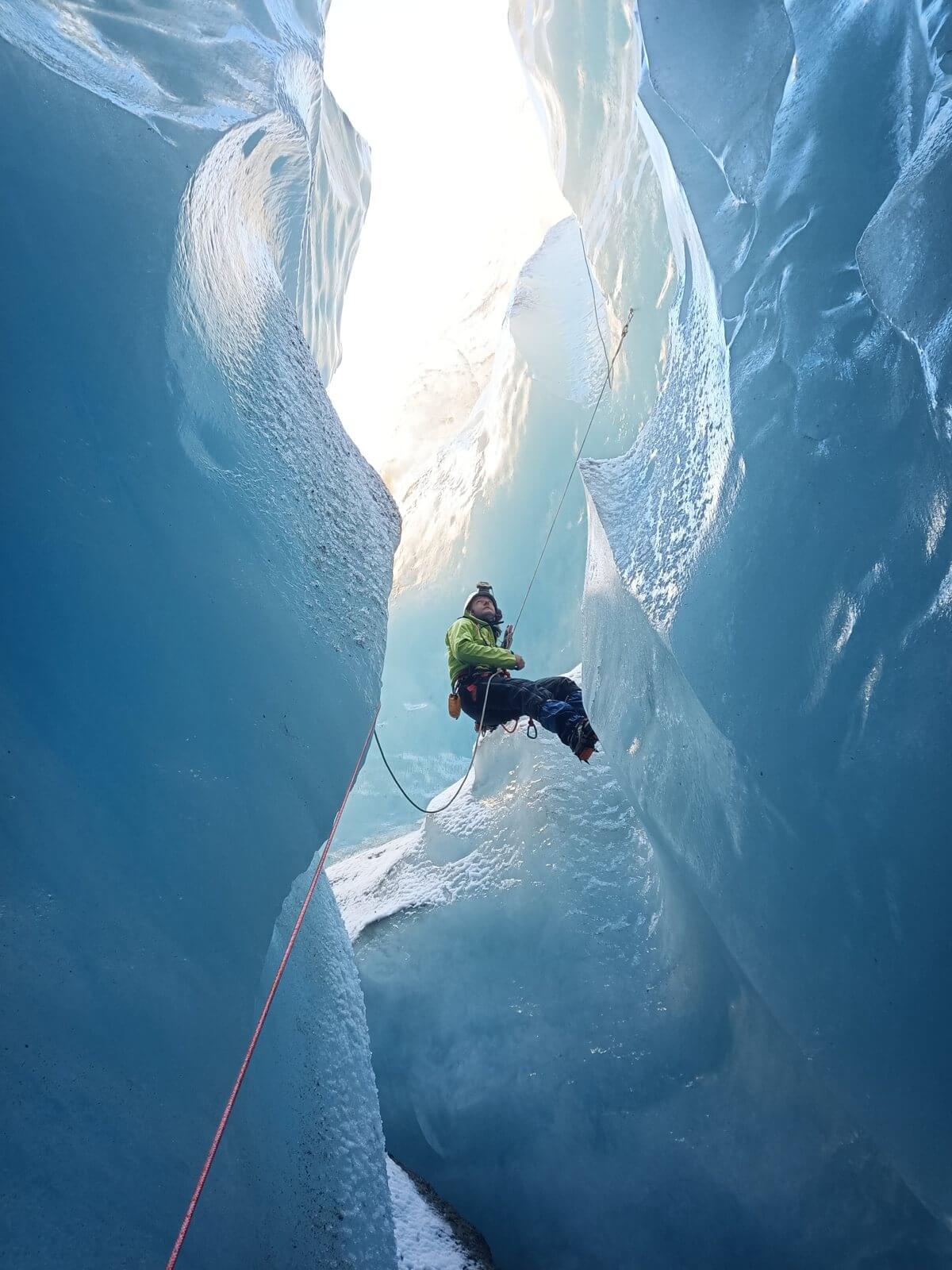Abseiling into a Mer de Glace moulin between two walls of blue ice